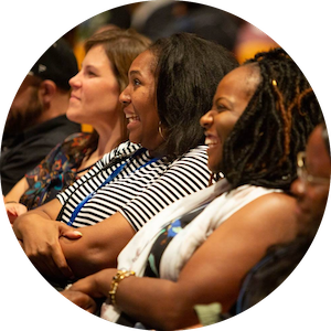Group of educators sitting together watching a presentation joyfully