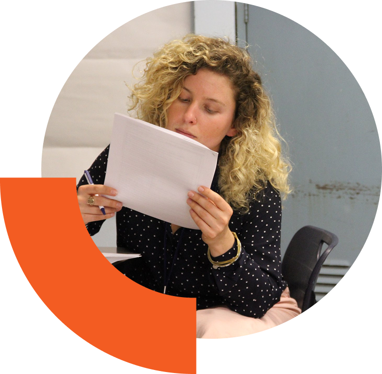 Woman reading a stack of papers intently.