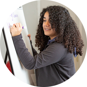 Young student writing on a large sticky pad